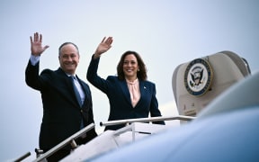US Vice President and 2024 Democratic presidential candidate Kamala Harris and Second Gentleman Doug Emhoff wave as they depart from Philadelphia International Airport in Philadelphia, Pennsylvania, August 6, 2024. Harris spoke during a campaign event at Temple University and is returning to Washington, DC. (Photo by Brendan SMIALOWSKI / POOL / AFP)