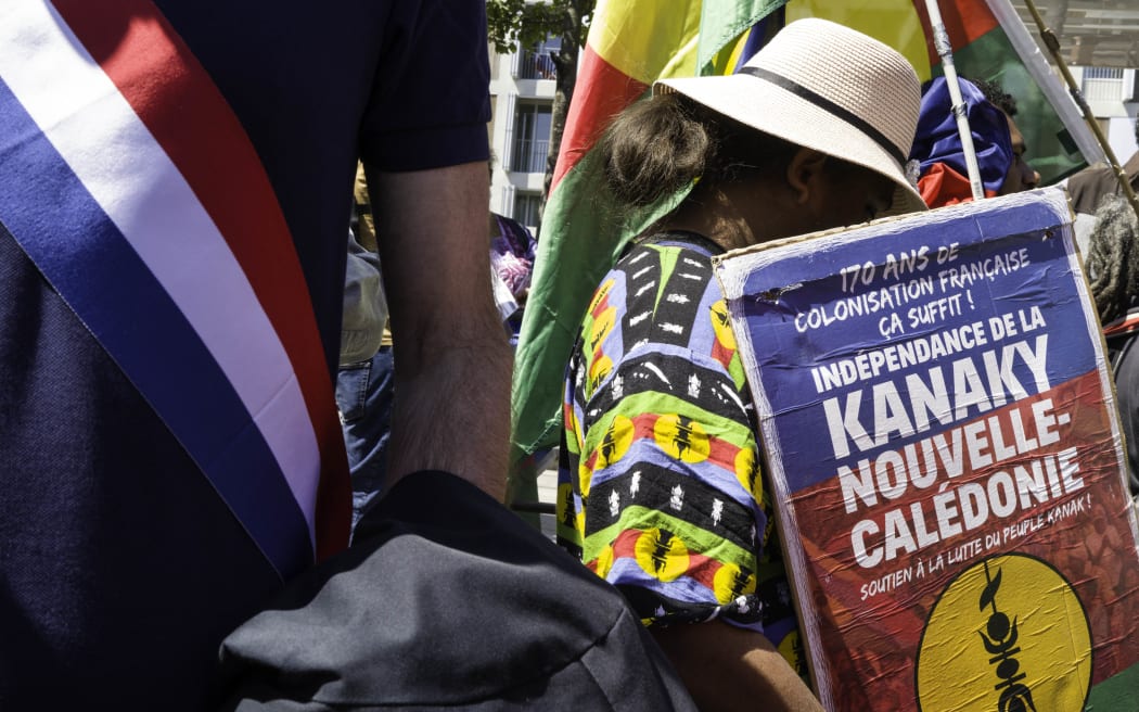 France, Paris, 2025-05-10. A woman carries a placard with the text ‘170 years of French colonisation is enough. Independence for New Caledonia and support for the Kanak people’. In memory of the 19 Kanaks killed in Ouvea by the French colonial state and the Kanak children and activists murdered in Noumea during the uprising on 13 May, a united march was organised. Photograph by Eric Broncard/Hans Lucas
France, Paris, 2025-05-10. Une femme porte une pancarte avec le texte «170 ans de colonisation Francaise ca suffit. Independance Nouvelle-Caledonie Soutient du peuple Kanak». En memoire des 19 Kanaks tues a Ouvea par l’Etat colonial francais et des enfants et militants kanaks assassines a Noumea lors de la revolte du 13 mai, une marche unitaire est organisee. Photographie par Eric Broncard/Hans Lucas (Photo by Eric Broncard / Hans Lucas / Hans Lucas via AFP)
