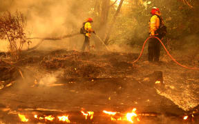 FAIRFIELD, CALIFORNIA - AUGUST 19: Pacific Gas and Electric firefighters extinguish spot fires as the LNU Lightning Complex fire burns through the area on August 19, 2020 in Fairfield, California.