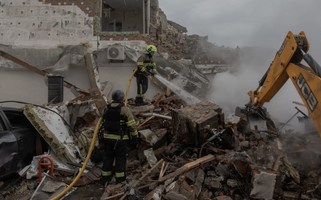 Ukrainian rescuers work at the site of heavily damaged residential buildings following a Russian air attack on the outskirts of Kyiv, on September 28, 2025, amid the Russian invasion of Ukraine. An overnight Russian barrage on Kyiv killed at least four people, including a 12-year-old girl, Ukrainian authorities said on September 28, 2025. (Photo by Roman PILIPEY / AFP)