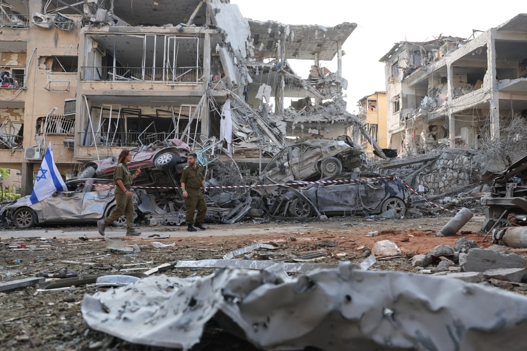 Israeli soldiers inspect a site hit by a missile fired from Iran in the Israeli city of Ramat Gan near Tel Aviv on June 14, 2025. Iran struck Israel early June 14, with barrages of missiles after a massive onslaught targeted the Islamic republic's nuclear and military facilities, and killed several top generals. (Photo by Jack GUEZ / AFP)
