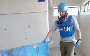 Hector Sharp assessing a school hit during the conflict.