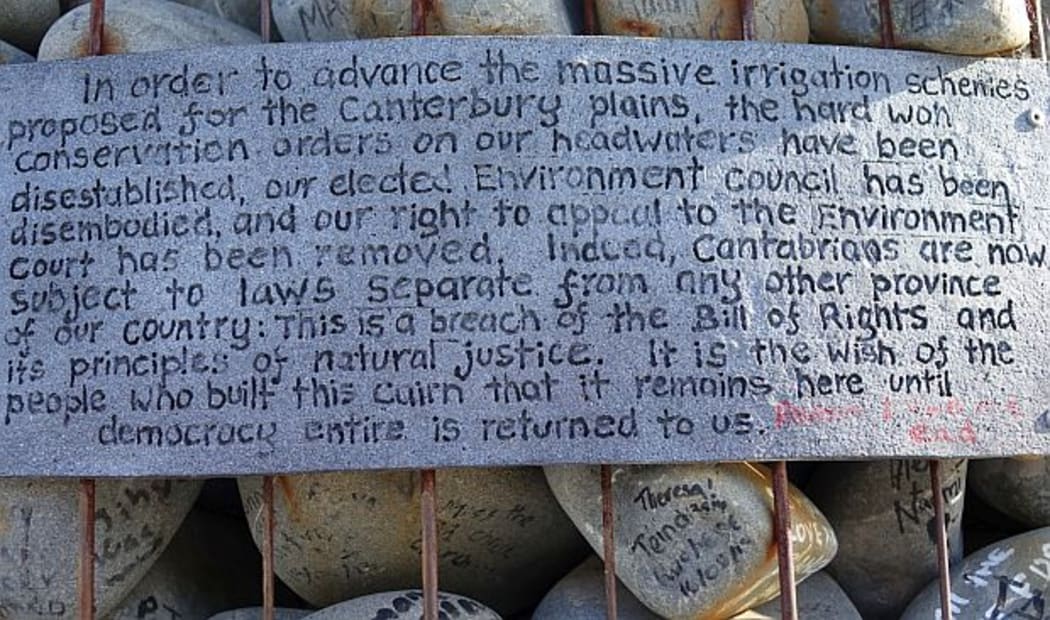 Sign on cairn made of river stones outlining protestors thoughts