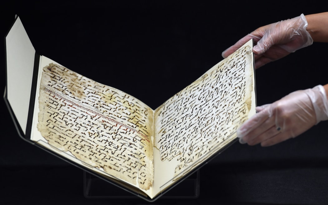 Marie Sviergula, conservator of the University of Birmingham holds a Koran manuscript thought to be at least 1,370 years old.
