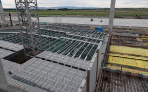 Roofs for the Ōhakea Air Force base aircraft hangars are being built on the ground. Cranes will hoist them into place.
