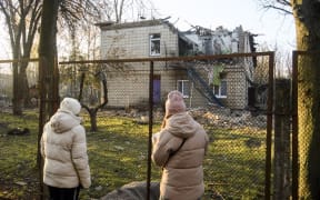 People are inspecting the damage to a kindergarten building caused by Russian drone strikes in Kyiv, Ukraine, on November 25, 2023.