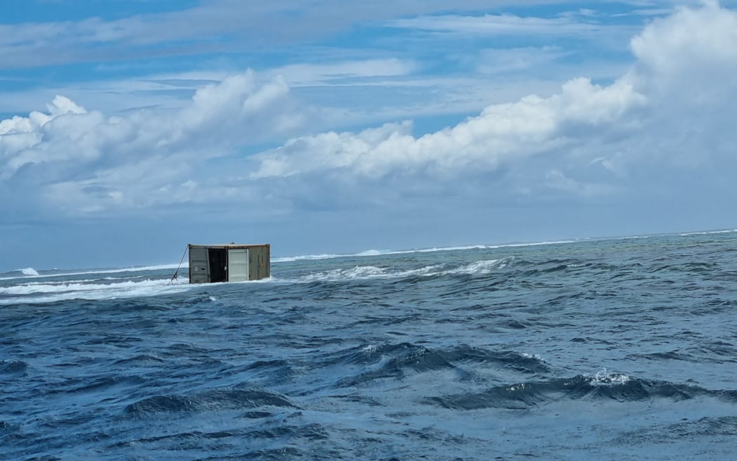 Three shipping containers floating in the sea near the sunken Manawanui ship.