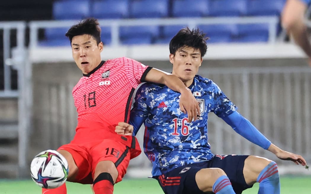 South Korea’s Lee?Jeonghyeop (L) and Japan’s TOMIYASU Takehiro struggle to keep a ball in the second half of the International Friendly Match between SAMURAI BLUE and Korea Republic National Team at Nissan Stadium in Yokohama, Kanagawa Prefecture on March 25, 2021. ( The Yomiuri Shimbun ) (Photo by Keita Iijima / Yomiuri / The Yomiuri Shimbun via AFP)