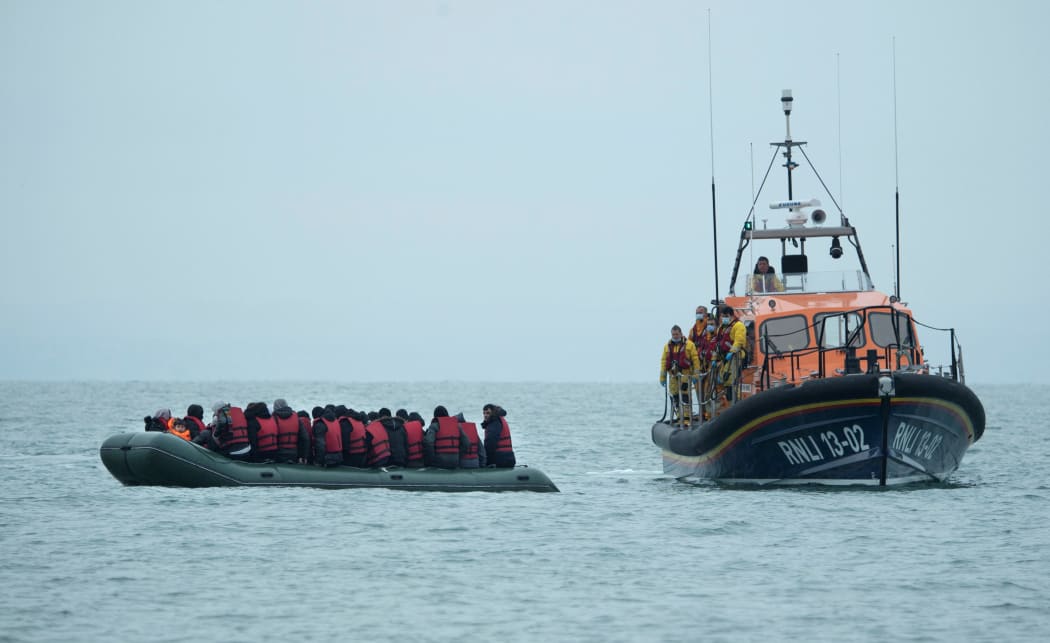Migrants are helped by RNLI (Royal National Lifeboat Institution) lifeboat before being taken to a beach in Dungeness, on the south-east coast of England, on November 24, 2021, after crossing the English Channel.