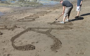 In the foreground is an italicised capital "A" while in the background Peter continues to work.