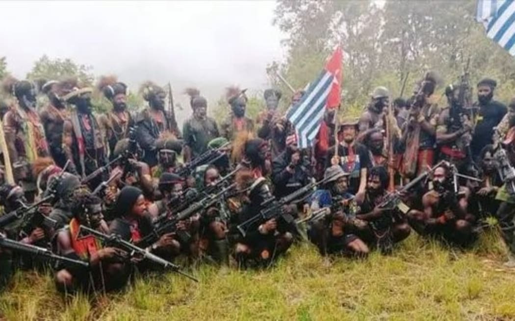 A man who is identified as Phillip Mehrtens, the New Zealand pilot who is said to be held hostage by a pro-independence group, sits among separatist fighters in Indonesia's Papua region in this undated handout picture released on May 26, 2023.
