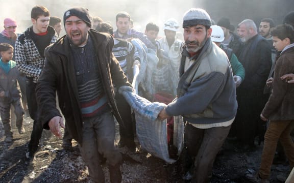 Syrians carrying a body after a reported airstrike in the Tariq al-Bab district of Aleppo on 1 February.