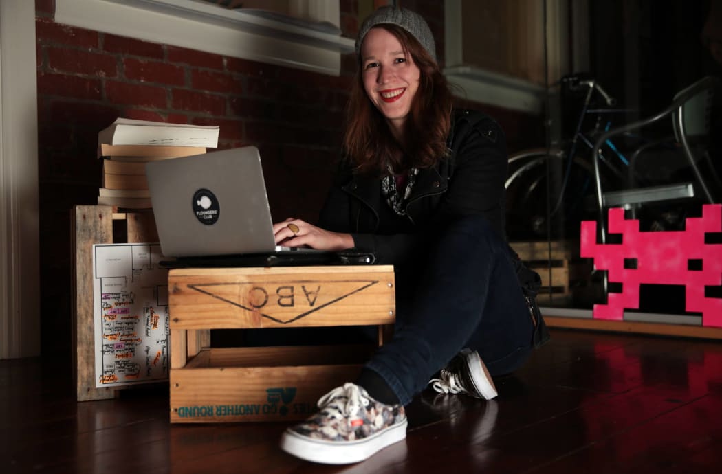 Anna Guenther, wearing sneakers, her laptop on a beer crate.