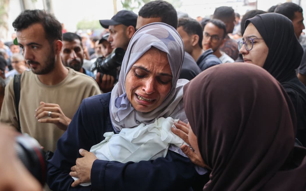 EDITORS NOTE: Graphic content / A Palestinian woman cries as she carries the body of a baby killed in Israeli strikes on Gaza City at dawn, before a funeral procession outside the Al-Shifa hospital on September 4, 2025, amid the war between Israel and the Hamas militant movement. Hamas's 2023 attack that triggered the war resulted in the deaths of 1,219 people, mostly civilians, according to an AFP tally based on Israeli figures. Israel's retaliatory offensive has killed at least 63,746 Palestinians, most of them civilians, according to figures from the health ministry in Hamas-run Gaza that the United Nations considers reliable. (Photo by Omar AL-QATTAA / AFP)