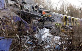 Firefighters and emergency doctors work at the site where two German commuter trains slammed into each other head on.