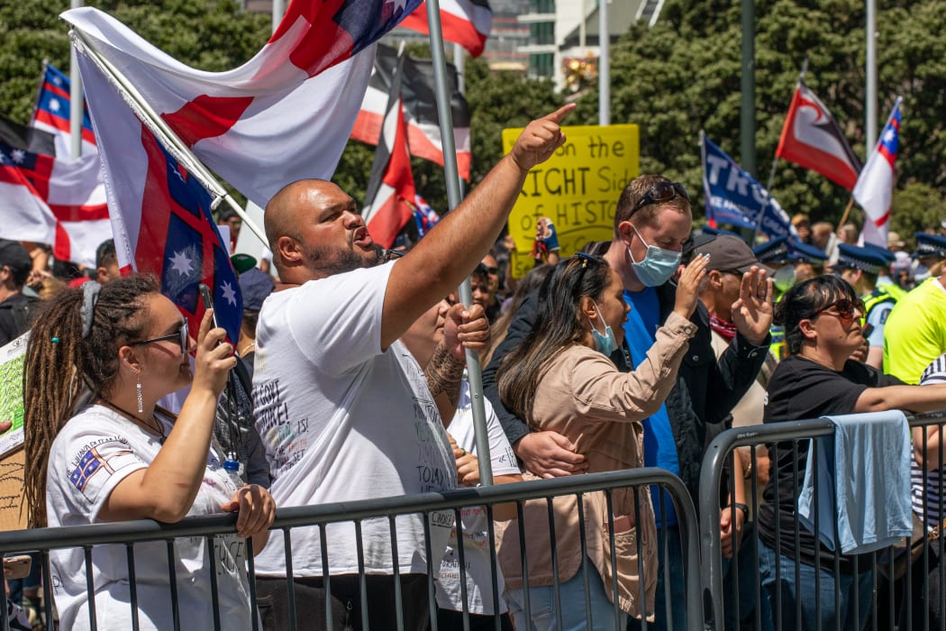 A few protestors moved forward to a barricade line at the base of Parliament's steps to vent spleen at the Police, now offering an authority to target. Note the two approaches: pointing and shouting, versus praying at the government.
