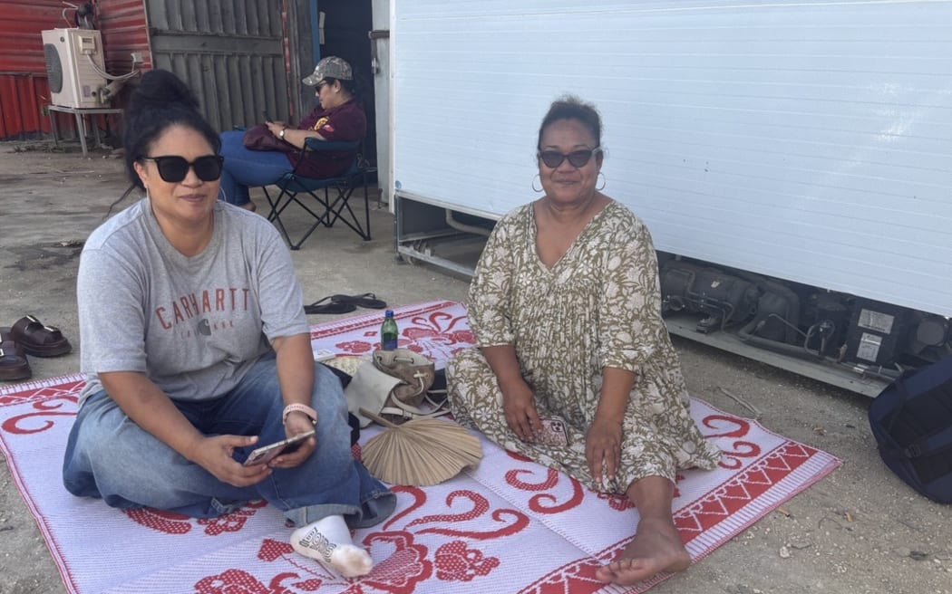 Nuku'alofa, Tonga - Seeking shelter in the shade Lavelua Tui (grey shirt) and Silia Vailala were among patrons queuing for petrol at a Nuku'alofa petrol station on November 18, 2025 amidst a fuel shortage.