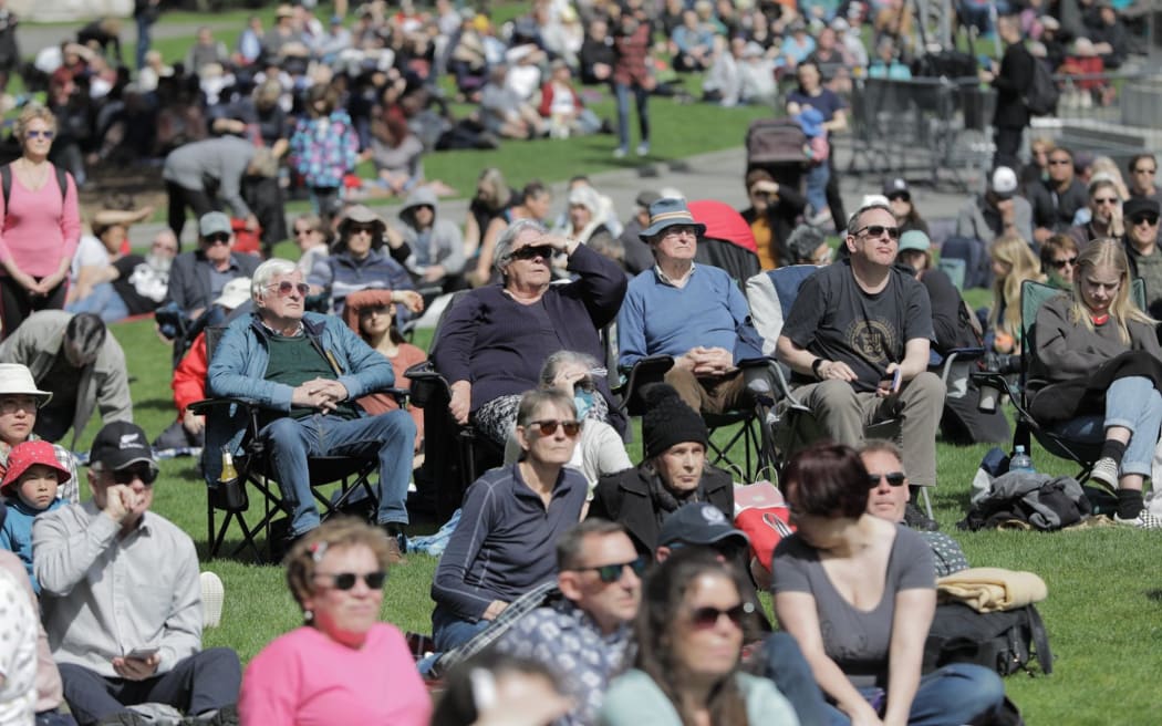 People gather outside Parliament to watch the Queen's state memorial service.