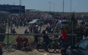 People gather to receive humanitarian aid in a car park in Mariupol on 29 April.