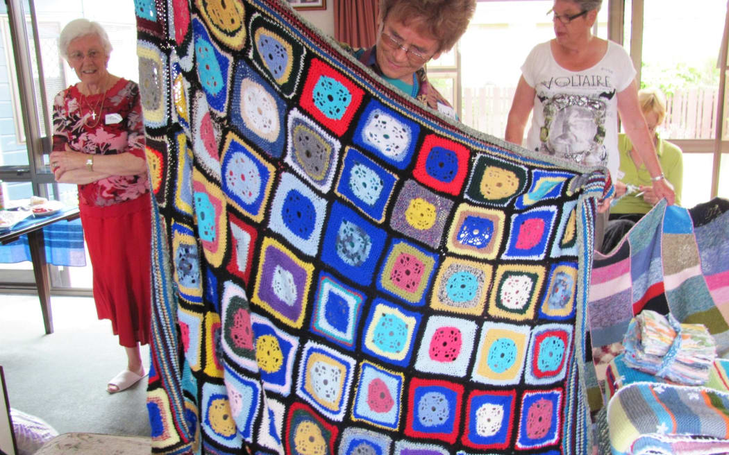 Operation Cover Up knitters inspect a blanket