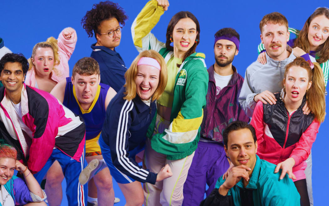 The cast of Bull Rush all pose in eighties-themed clothes, like bright windbreaker jackets, fuzzy headbands, and side ponytails. They smile at the camera.