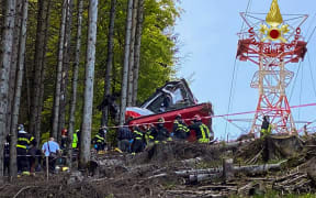 A photo taken and handout on May 23, 2021 by The Italian Firefighters "Vigili del Fuoco" shows rescuers working by a cable car that crashed to the ground in the resort town of Stresa on the shores of Lake Maggiore in the Piedmont region.