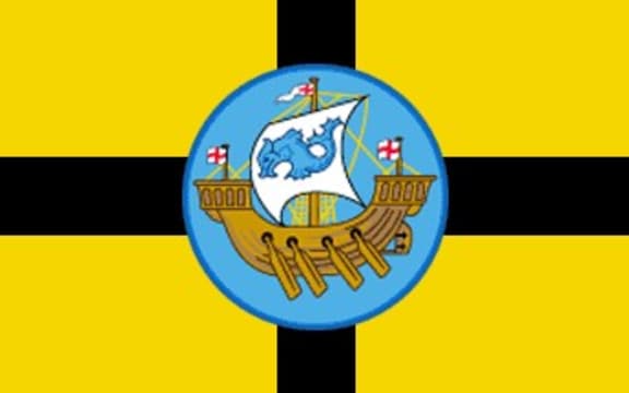 A yellow flag with a black cross and a picture of a ship with a dolphin on the sail.