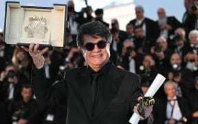 Iranian director and screenwriter and producer Jafar Panahi poses with the trophy during a photocall after winning the Palme d'Or for the film "Un simple accident" (A Simple Accident) during the closing ceremony at the 78th edition of the Cannes Film Festival in Cannes, southern France, on May 24, 2025. (Photo by Bertrand GUAY / AFP)
