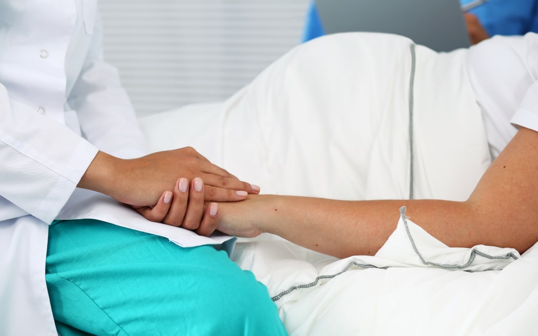 medical professional holding pregant woman's hand