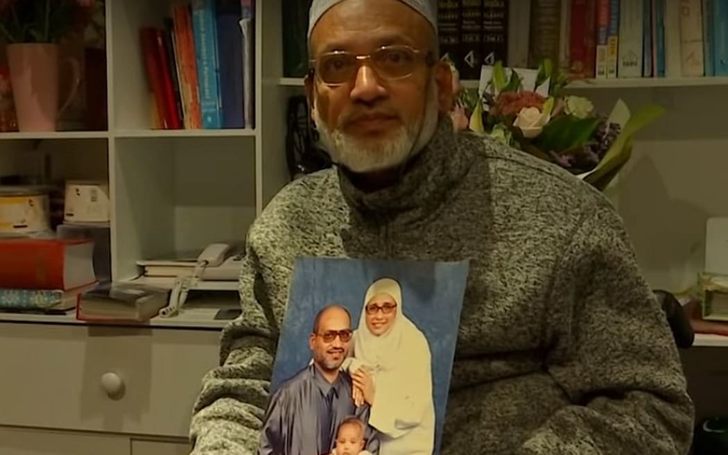 Farid Ahmed holds a picture of his family