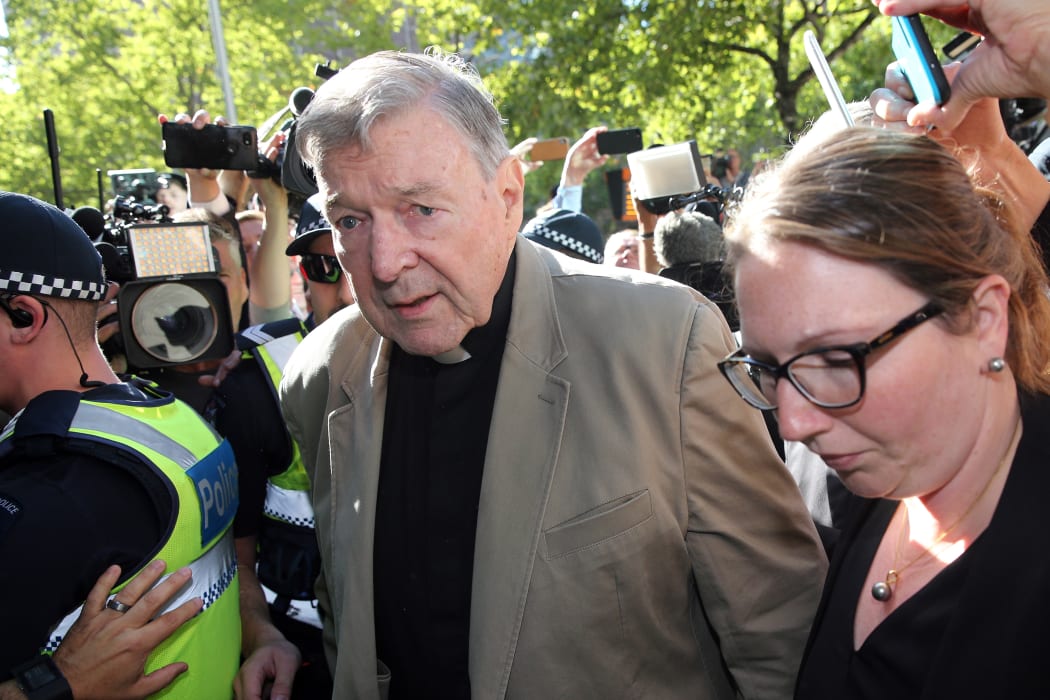This file photo taken on February 27, 2019 shows Australian Cardinal George Pell (C) making his way to the court in Melbourne. - Cardinal George Pell will walk free from jail after winning a long-running battle to overturn his child sex abuse convictions in Australia's High Court on April 7, 2020.