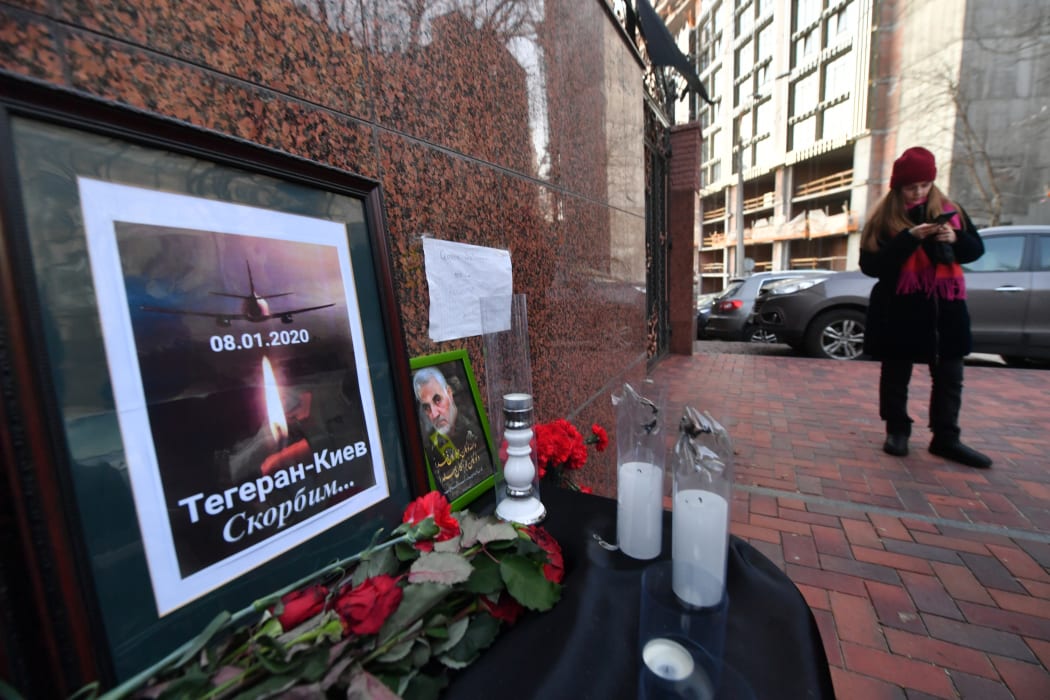 Flowers, candles and a placard reading "Tehran-Kiev We mourn" outside the Iranian embassy in Kiev on 8 January, in remembrance of the victims of the Ukraine International crash in Tehran.