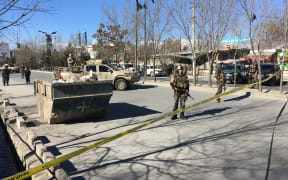 Afghan security forces stand guard near the site of multiple blasts in Kabul on December 28.