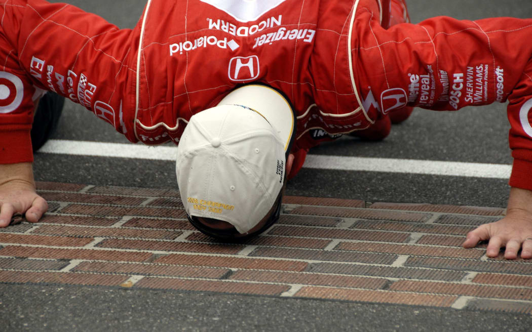 Scott Dixon does the traditional kissing of the bricks after winning the 92nd running of the Indy 500 in 2008.