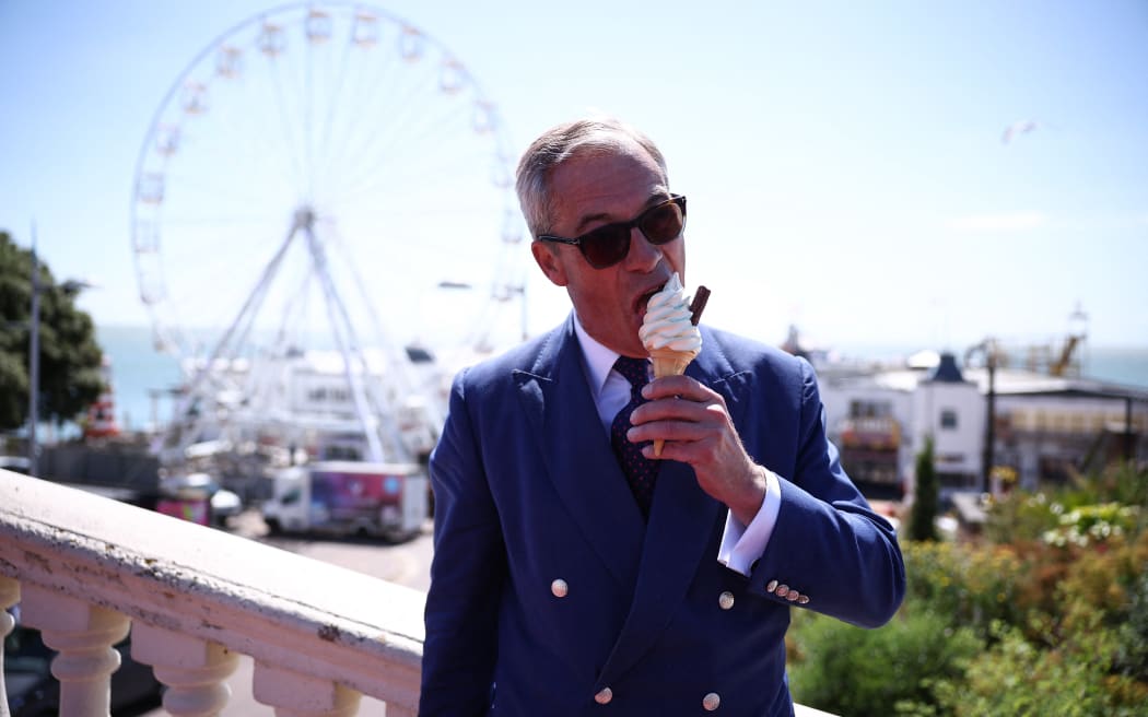 Reform UK leader Nigel Farage eats a 99 Flake ice cream in Clacton-on-Sea, eastern England, on July 4, 2024 as Britain holds a general election. (Photo by HENRY NICHOLLS / AFP)