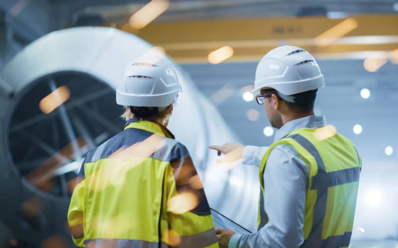Two Heavy Industry Engineers Stand in Pipe Manufacturing Factory,
