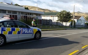 Police stand guard at the cordon on Warspite Avenue on Saturday morning.
