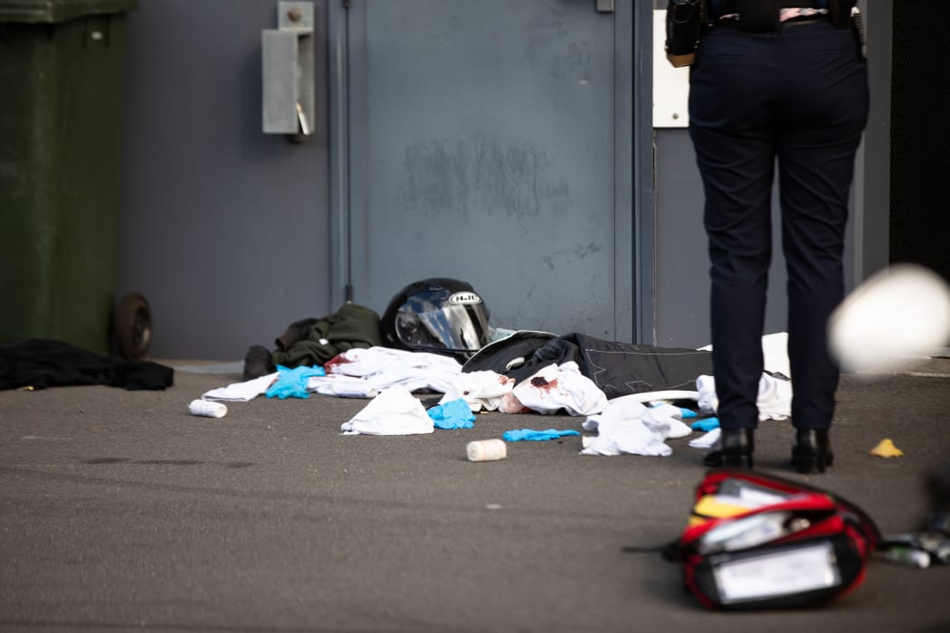 Clothes with what appears to be blood on them and a helmet are strewn across a cordoned off area of the Harley Davidson store at Mt Wellington.