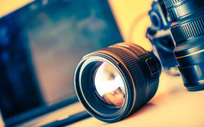 Photographer Desk with Lenses and Laptop Computer in the Background. Photography Theme.