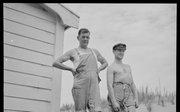 Two men and a dog on the porch of a house at Glinks Gully