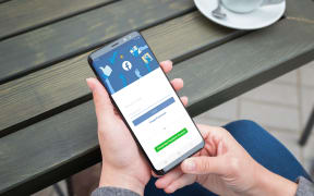 SARAJEVO, BOSNIA AND HERZEGOVINA - JULY 14, 2019: Woman use Samsung Galaxy smartphone to log in on the Facebook social network account.