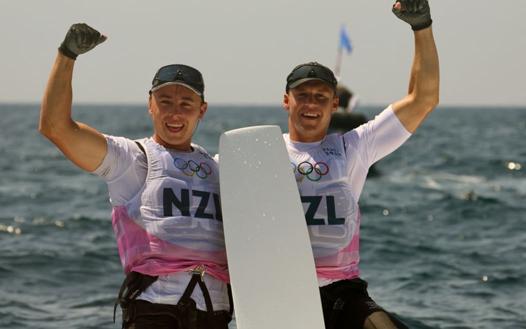New Zealand's duo Isaac Mchardie and William Mckenzie celebrate  after winning the silver medal at the end of the medal race of the men’s 49er skiff event during the Paris 2024 Olympic Games sailing competition at the Roucas-Blanc Marina in Marseille on August 2, 2024. (Photo by Clement MAHOUDEAU / AFP)
