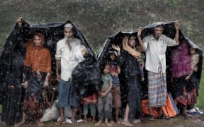 Rohingya refugees shelter from the rain in a camp in Cox's Bazar, Bangladesh, September 17, 2017.