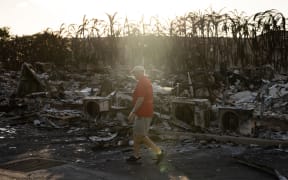 A resident looks around a charred apartment complex in the aftermath of a wildfire in Lahaina, western Maui, Hawaii on 12 August, 2023.