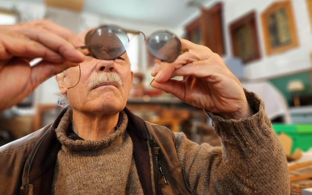 Ian Day inspects a pair of antique sunglasses