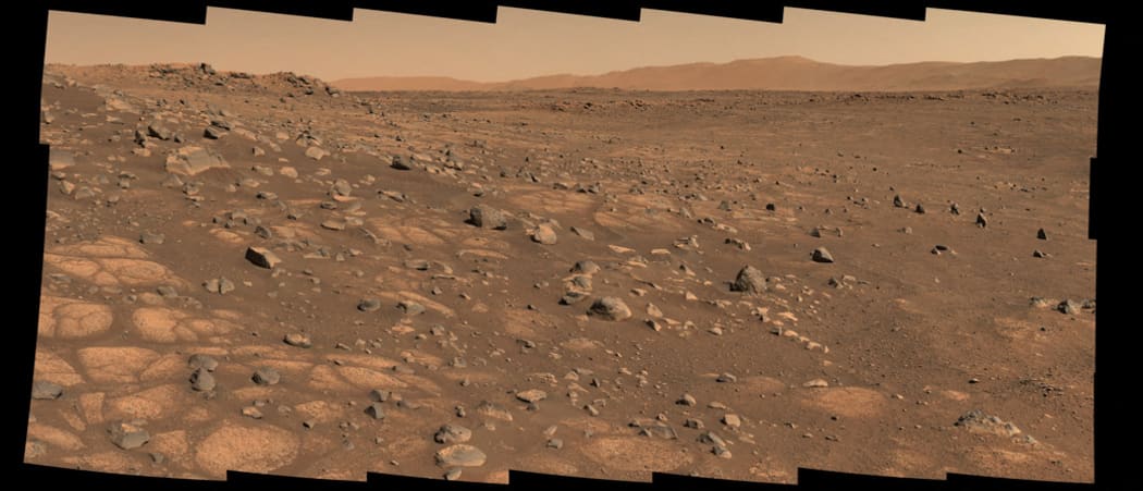 This Nasa photo taken 8 July 2021, shows the 'Cratered Floor Fractured Rough' geologic unit at Jezero Crater. A light-colored, paver stone, like the ones seen in this mosaic image, will be the likely target for first sampling by the Perseverance rover.