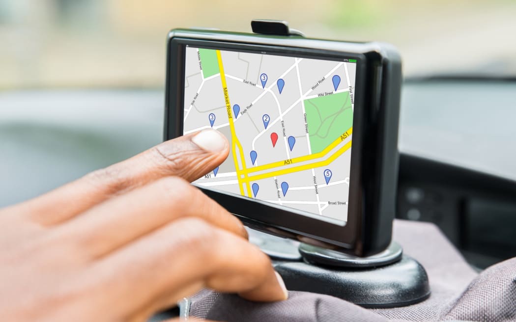 Close-up Of Person's Hand Using GPS Service While Driving Car