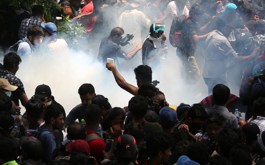Police use tear gas as Protesters storm the compound of prime minister's office, demanding Ranil Wickremesinghe resign after president Gotabaya Rajapaksa fled the country amid economic crisis in Colombo, Sri Lanka,July 13, 2022. (Photo by Pradeep Dambarage/NurPhoto) (Photo by Pradeep Dambarage / NurPhoto / NurPhoto via AFP)
