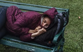 File image: A homeless woman sleeps on a bench