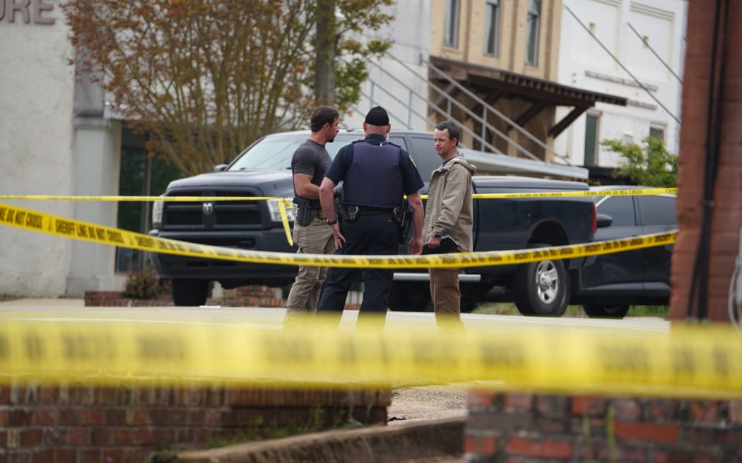 Investigators are seen outside the crime scene following a shooting in Dadeville, Alabama. Four people were killed and 28 injured in the shooting during a 16th birthday party at a dance studio on the night of 15 April, 2023.